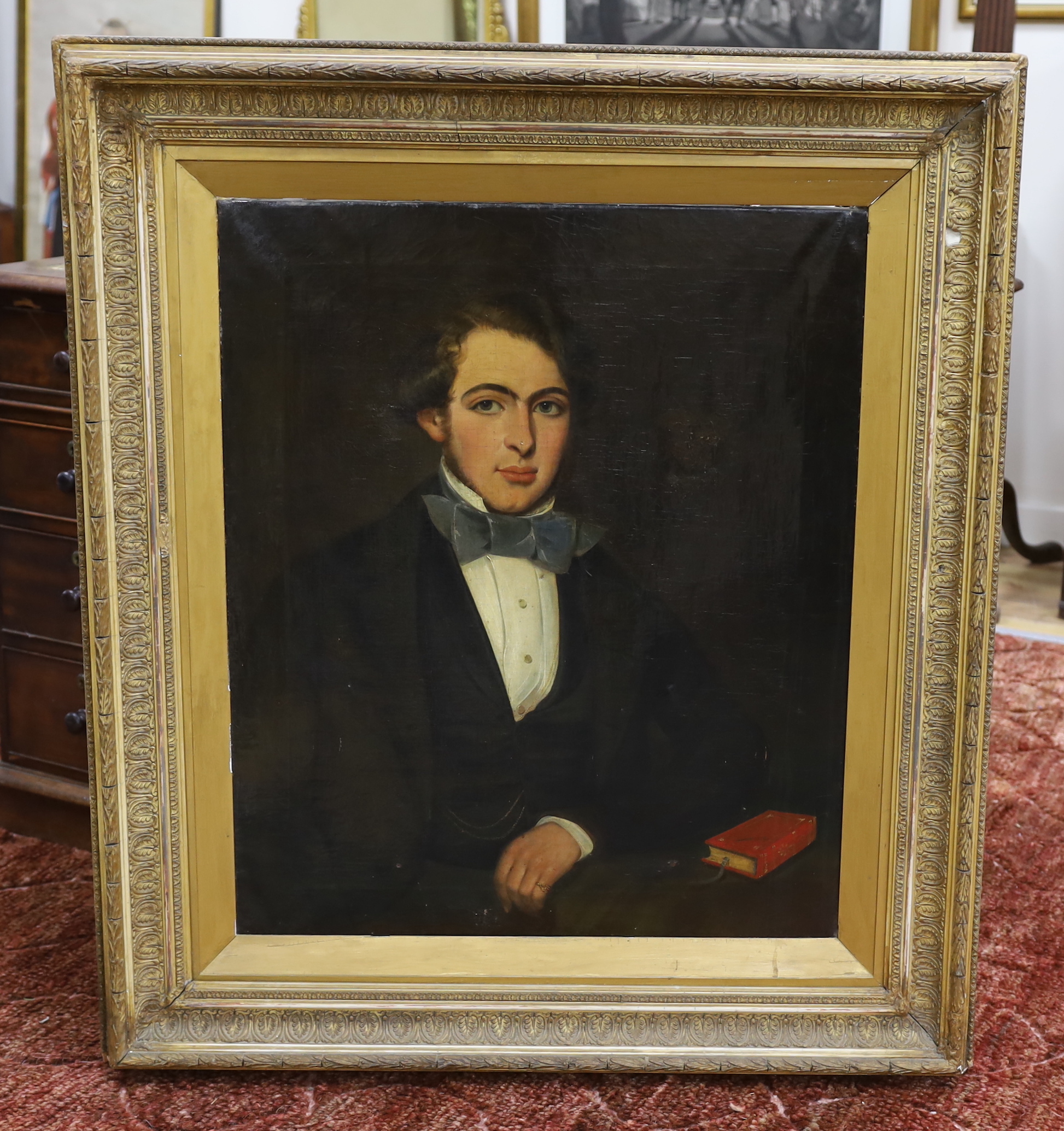 19th century Scottish School, oil on canvas, Portrait of a young gentleman seated with a John Milton book, partially indistinct ink inscription verso, ‘.... on his 19th birthday, 74 x 62cm, housed in a Victorian gilt fra